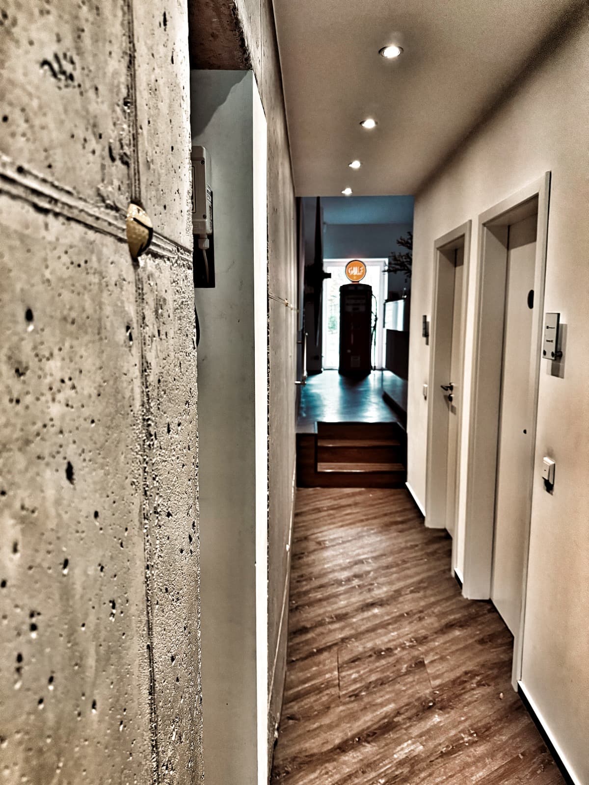 Moderner Flur der Rheinkanzlei mit Betonwand und Holzfußboden